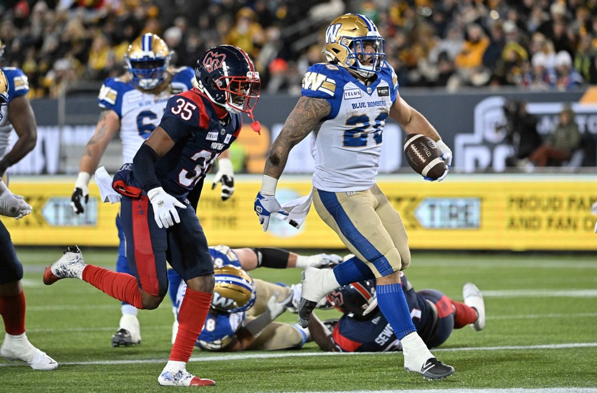Nov 19, 2023; Hamilton, Ontario, CAN;  Winnipeg Blue Bombers running back Brady Oliveira (20) scores a touchdown past Montreal Alouettes defensive back Reggie Stubblefield (35) in the first half at Tim Hortons Field. Mandatory Credit: Dan Hamilton-USA TODAY Sports