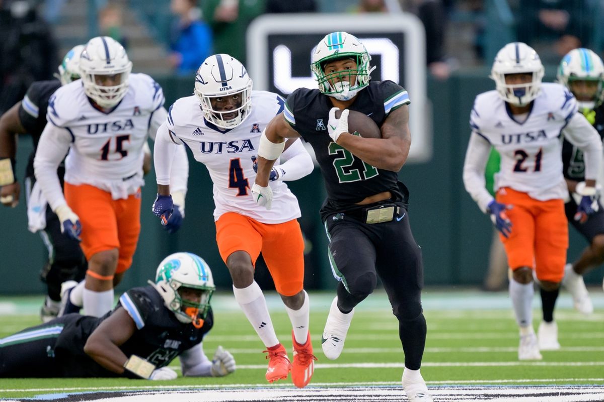 Nov 24, 2023; New Orleans, Louisiana, USA; Tulane Green Wave running back Makhi Hughes (21) runs against UTSA Roadrunners running back Kevorian Barnes (4) during the first half at Yulman Stadium. Mandatory Credit: Matthew Hinton-Imagn Images