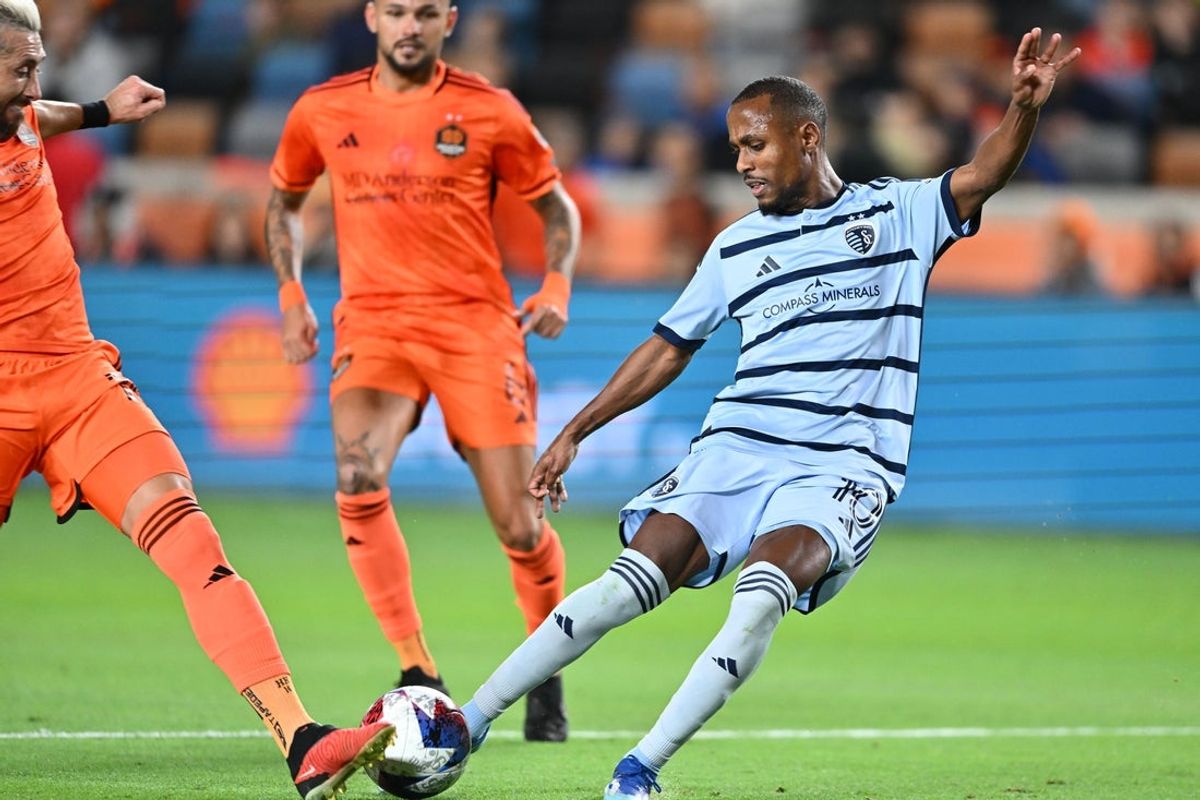 Nov 26, 2023; Houston, Texas, USA; Sporting Kansas City midfielder Gadi Kinda (10) shoots the ball against Houston Dynamo midfielder Hector Herrera (16) during the first half for the MLS Cup Western Conference Semifinal match at Shell Energy Stadium. Mandatory Credit: Maria Lysaker-Imagn Images