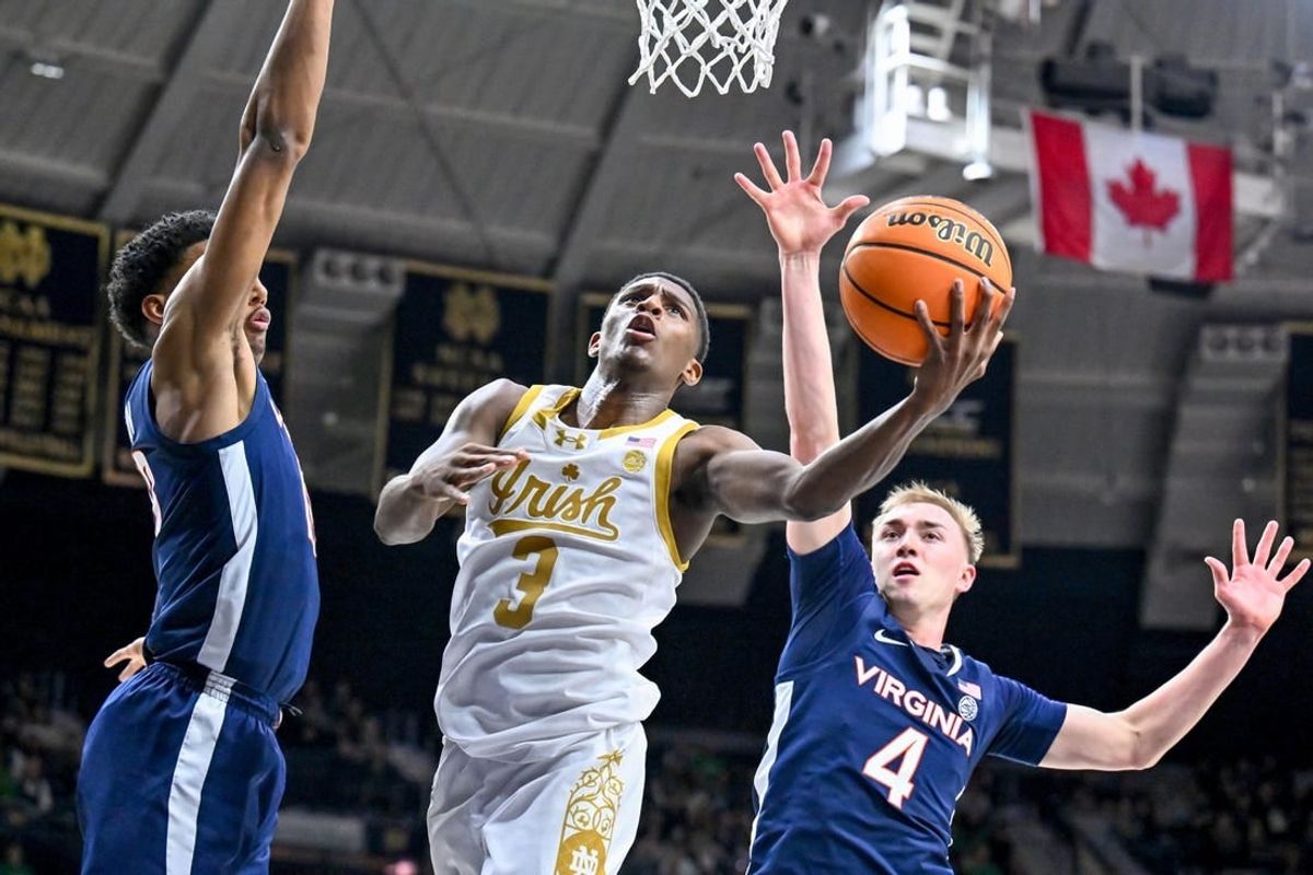 Dec 30, 2023; South Bend, Indiana, USA; Notre Dame Fighting Irish guard Markus Burton (3) shoots between Virginia Cavaliers guard Ryan Dunn (13) and guard Andrew Rohde (4) in the first half at the Purcell Pavilion.