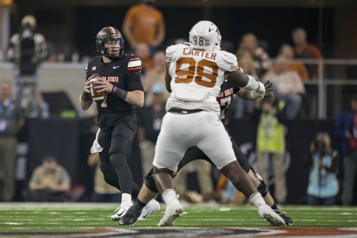 Dec 2, 2023; Arlington, TX, USA; Oklahoma State Cowboys quarterback Alan Bowman (7) and Texas Longhorns defensive lineman Trill Carter (98) in action during the game between the Texas Longhorns and the Oklahoma State Cowboys at AT&T Stadium. Mandatory Credit: Jerome Miron-Imagn Images