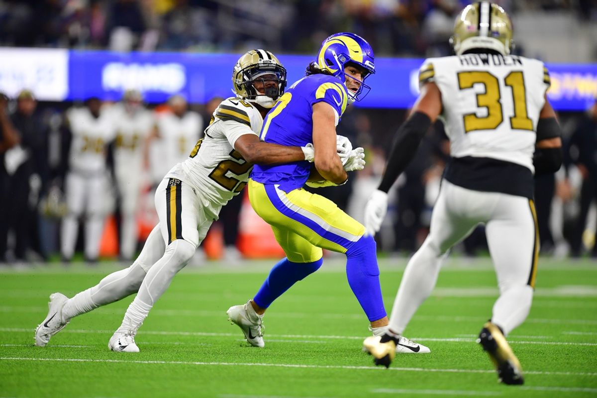 Dec 21, 2023; Inglewood, California, USA; Los Angeles Rams wide receiver Puka Nacua (17) moves the ball against New Orleans Saints cornerback Marshon Lattimore (23) and safety Jordan Howden (31) during the first half at SoFi Stadium. Mandatory Credit: Gary A. Vasquez-Imagn Images