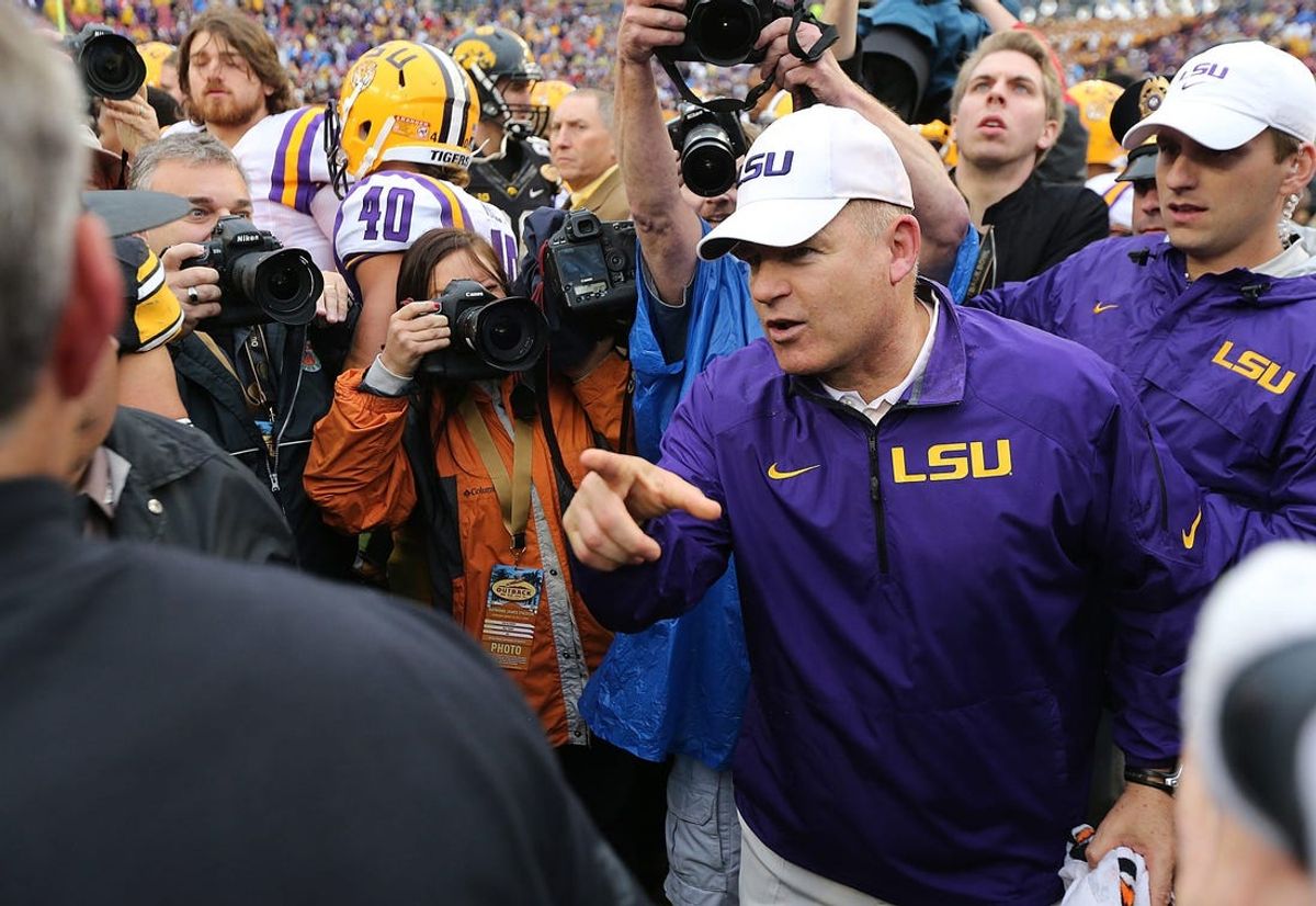Louisiana State coach Les Miles meets with Iowa coach Kirk Ferentz following Miles and LSU's 21-14 win over the Hawkeyes on Wednesday, Jan. 1, 2014, in Tampa, FL.