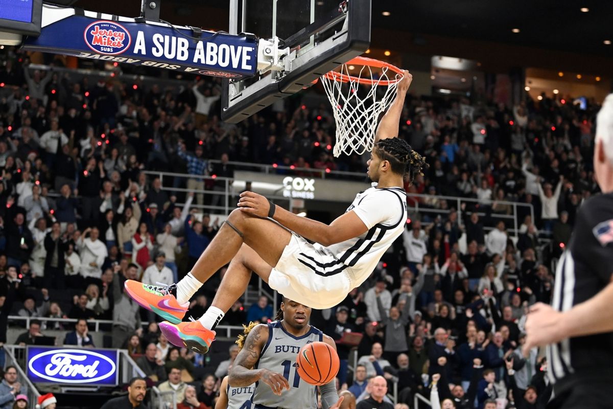 Dec 23, 2023; Providence, Rhode Island, USA; Providence Friars forward Bryce Hopkins (23) hangs from the rim after making a basket against the Butler Bulldogs during the first half at Amica Mutual Pavilion. Mandatory Credit: Eric Canha-Imagn Images