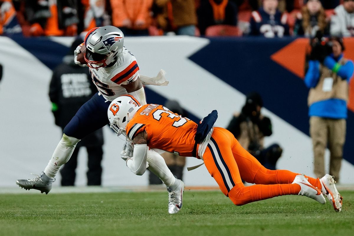 Dec 24, 2023; Denver, Colorado, USA; New England Patriots running back Ezekiel Elliott (15) is tackled by Denver Broncos safety Justin Simmons (31) in the fourth quarter at Empower Field at Mile High. Mandatory Credit: Isaiah J. Downing-USA TODAY Sports