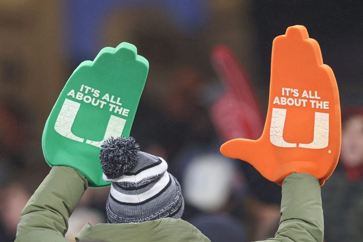 Dec 28, 2023; Bronx, NY, USA; A Miami Hurricanes fan holds up foam hands during the second half of the 2023 Pinstripe Bowl against the Rutgers Scarlet Knights at Yankee Stadium. Mandatory Credit: Vincent Carchietta-USA TODAY Sports
