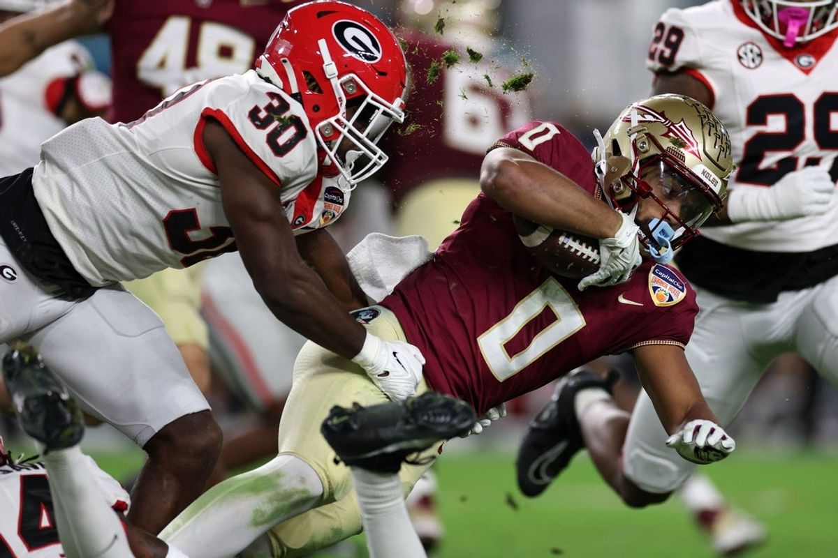 Dec 30, 2023; Miami Gardens, FL, USA; Florida State Seminoles wide receiver Ja'Khi Douglas (0) is tackled by Georgia Bulldogs linebacker Terrell Foster (30) during the Capital One Orange Bowl at Hard Rock Stadium. Mandatory Credit: Nathan Ray Seebeck-Imagn Images