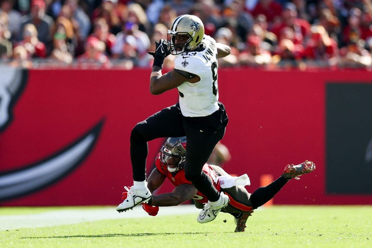 Dec 31, 2023; Tampa, Florida, USA;  New Orleans Saints tight end Juwan Johnson (83) breaks a tackle from Tampa Bay Buccaneers safety Christian Izien (29) in the second quarter at Raymond James Stadium. Mandatory Credit: Nathan Ray Seebeck-USA TODAY Sports