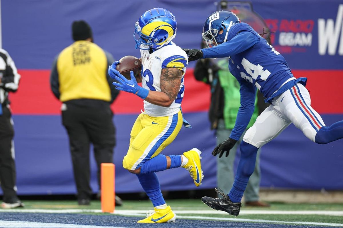 Dec 31, 2023; East Rutherford, New Jersey, USA; Los Angeles Rams running back Kyren Williams (23) scores a rushing touchdown during the second half in front of New York Giants safety Dane Belton (24) at MetLife Stadium. Mandatory Credit: Vincent Carchietta-USA TODAY Sports