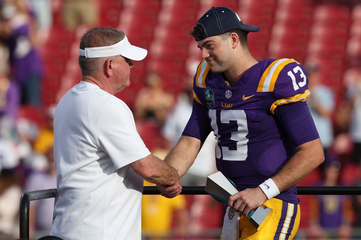 Jan 1, 2024; Tampa, FL, USA; LSU Tigers quarterback Garrett Nussmeier (13) is congratulated by head coach Brian Kelly after being awarded the MVP award after beating the Wisconsin Badgers in the ReliaQuest Bowl at Raymond James Stadium. Mandatory Credit: Nathan Ray Seebeck-USA TODAY Sports