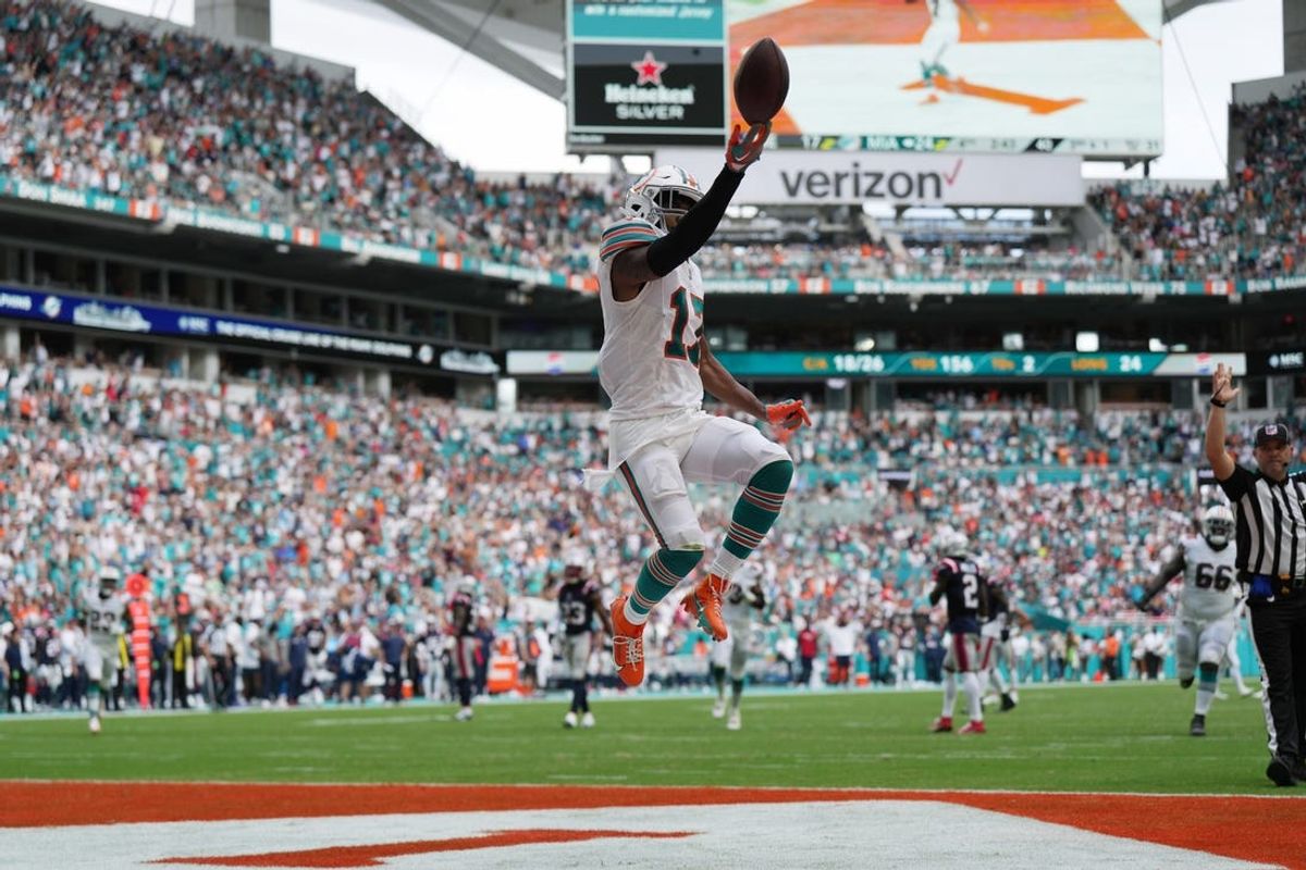 Miami Dolphins wide receiver Jaylen Waddle (17) flips the ball in the air as he scores a touchdown against the New England Patriots during the second half of an NFL game at Hard Rock Stadium in Miami Gardens, Oct. 29, 2023.