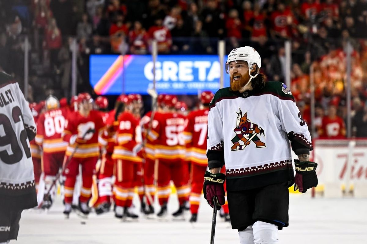 Jan 16, 2024; Calgary, Alberta, CAN; Arizona Coyotes center Liam O'Brien (38) looks on while Calgary Flames celebrate after scoring in overtime at Scotiabank Saddledome. Mandatory Credit: Brett Holmes-USA TODAY Sports