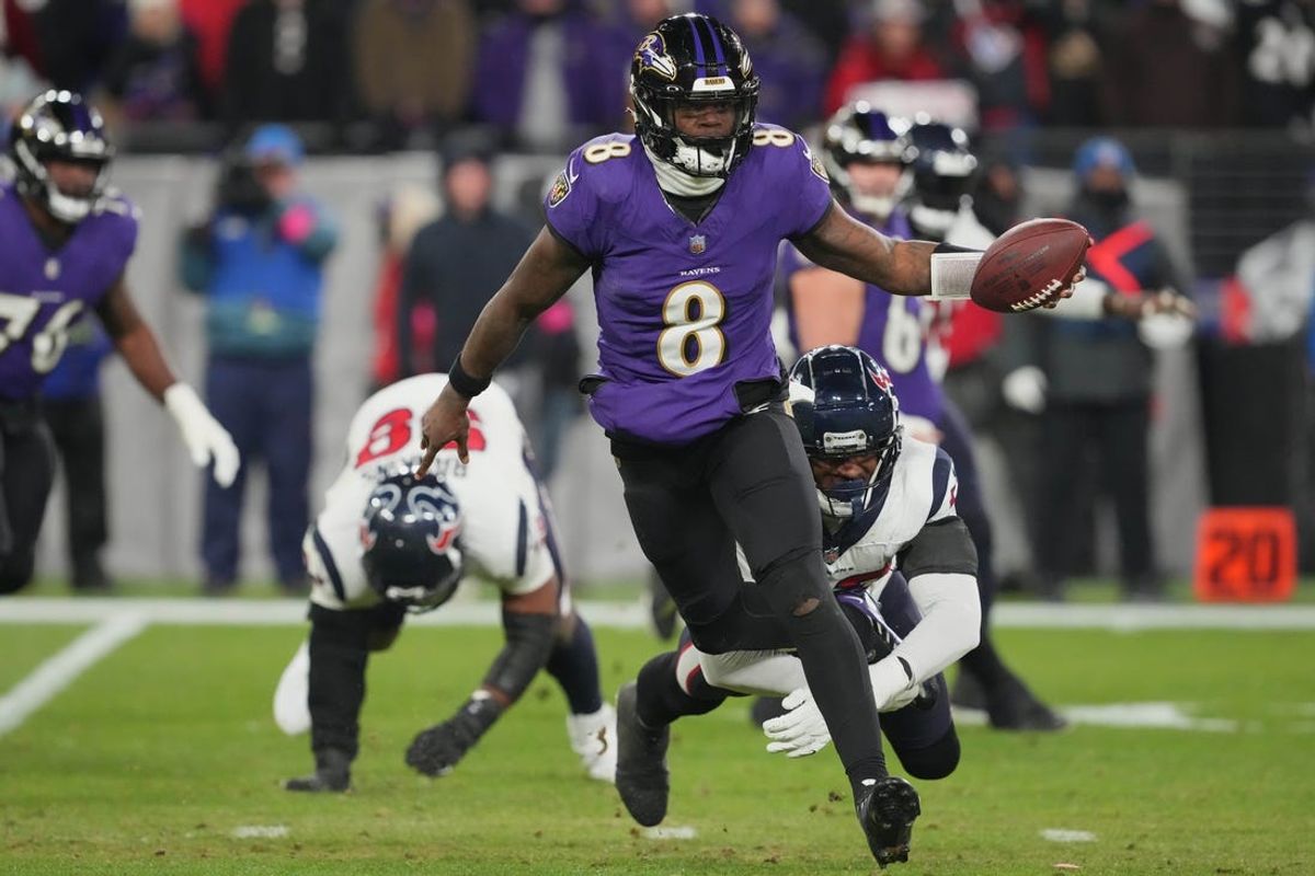 Jan 20, 2024; Baltimore, MD, USA; Baltimore Ravens quarterback Lamar Jackson (8) runs the ball against Houston Texans defensive end Jonathan Greenard (behind Jackson) during the second quarter of a 2024 AFC divisional round game at M&T Bank Stadium. Mandatory Credit: Mitch Stringer-USA TODAY Sports