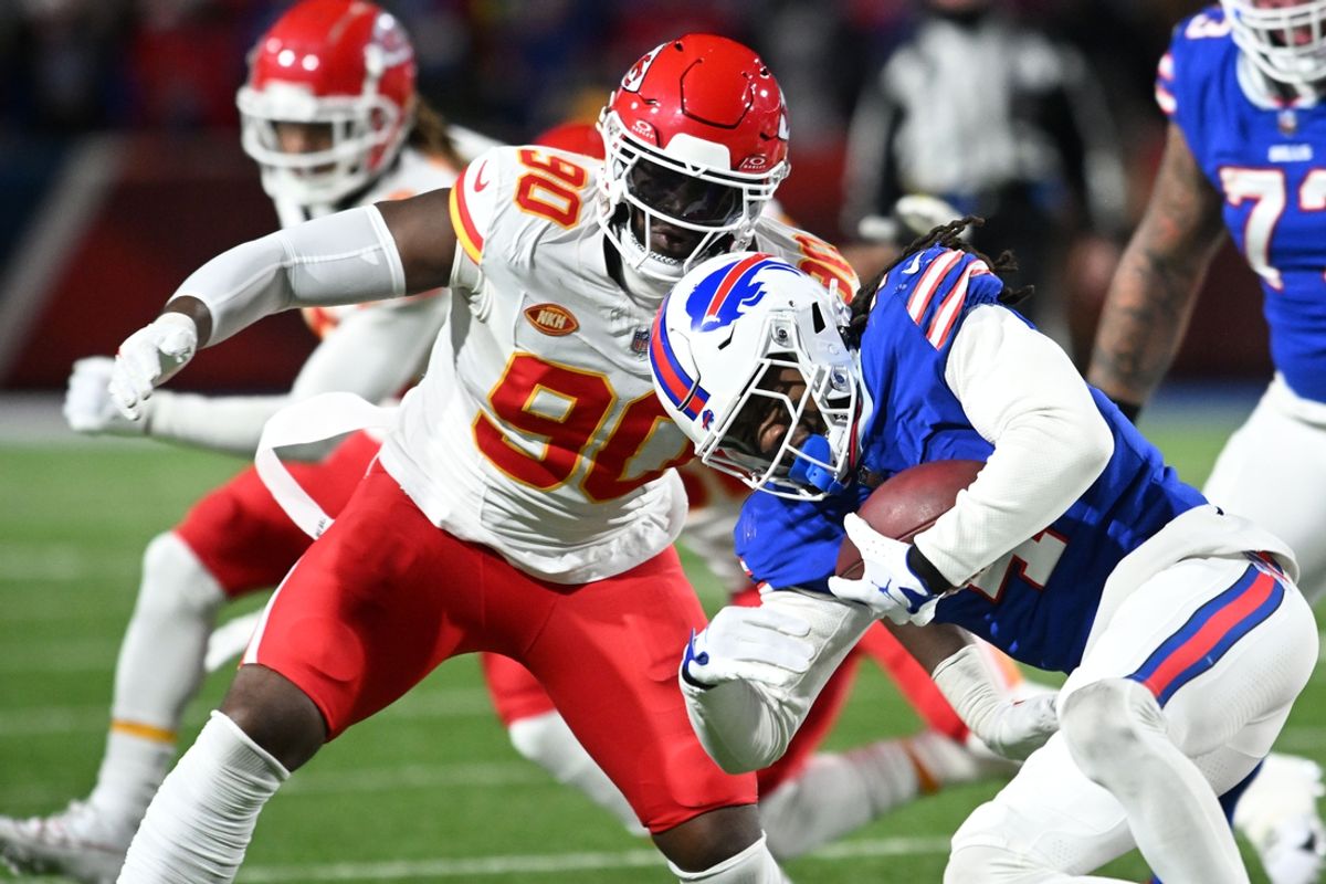 Jan 21, 2024; Orchard Park, New York, USA; Buffalo Bills running back James Cook (4) rushes the ball against Kansas City Chiefs defensive end Charles Omenihu (90) in the first half of the 2024 AFC divisional round game at Highmark Stadium. Mandatory Credit: Mark Konezny-Imagn Images