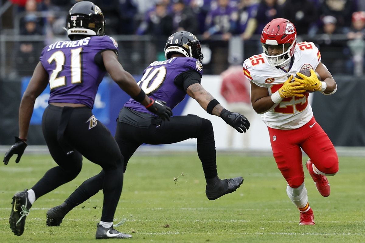 Jan 28, 2024; Baltimore, Maryland, USA; Kansas City Chiefs running back Clyde Edwards-Helaire (25) carries the ball as Baltimore Ravens cornerback Arthur Maulet (10) and Ravens cornerback Brandon Stephens (21) defend in the AFC Championship football game at M&T Bank Stadium. Mandatory Credit: Geoff Burke-USA TODAY Sports