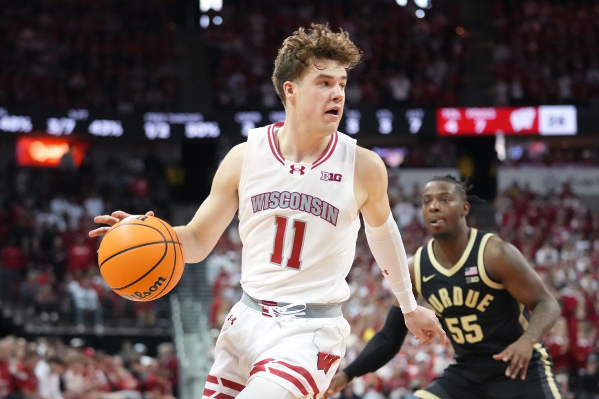 Feb 4, 2024; Madison, Wisconsin, USA; Wisconsin Badgers guard Max Klesmit (11) dribbles the ball against Purdue Boilermakers guard Lance Jones (55) during the first half at the Kohl Center. Mandatory Credit: Kayla Wolf-Imagn Images