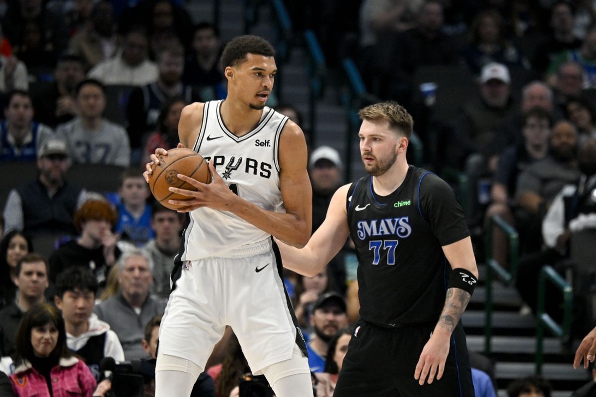 Feb 14, 2024; Dallas, Texas, USA; San Antonio Spurs center Victor Wembanyama (1) looks to move the ball past Dallas Mavericks guard Luka Doncic (77) during the fist quarter at the American Airlines Center. Mandatory Credit: Jerome Miron-Imagn Images