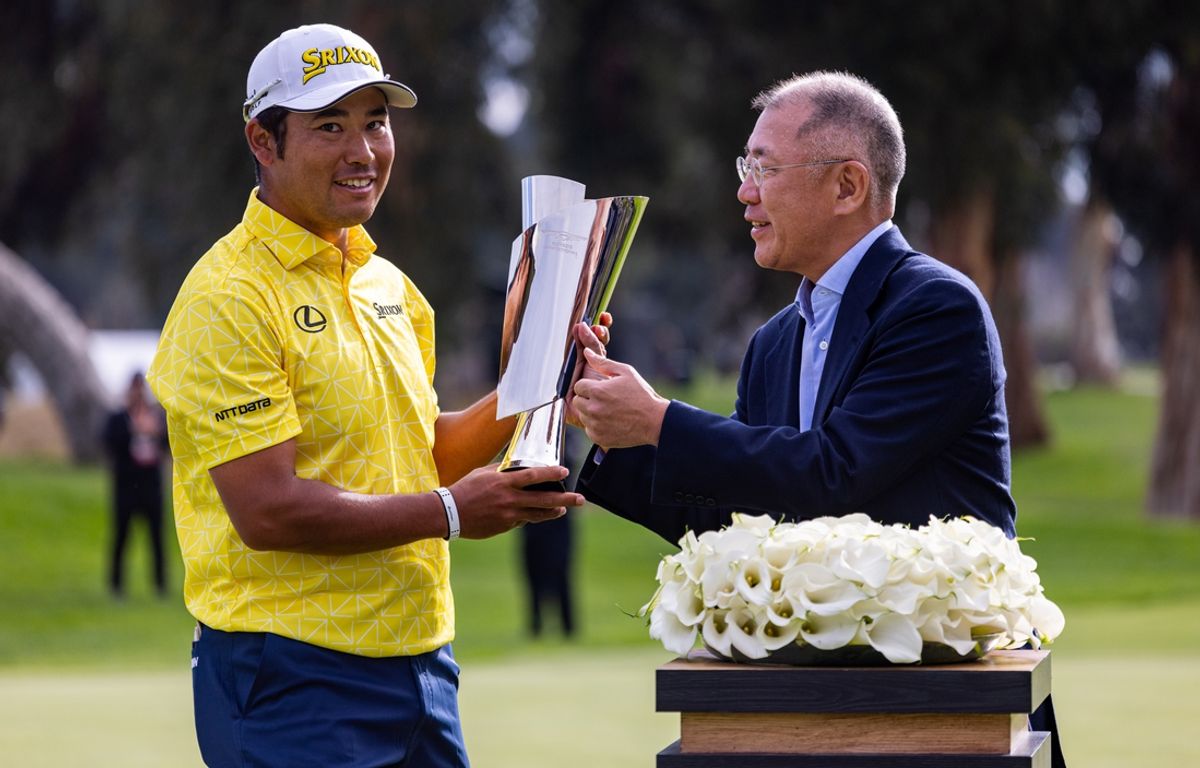 Feb 18, 2024; Pacific Palisades, California, USA; Hideki Matsuyama is presented the trophy after winning The Genesis Invitational golf tournament at Riveria Country Club. Mandatory Credit: Jason Parkhurst-Imagn Images