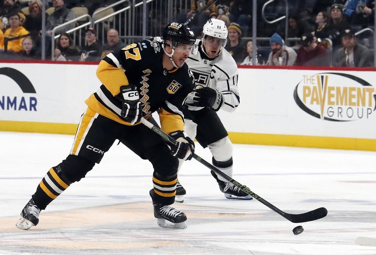Feb 18, 2024; Pittsburgh, Pennsylvania, USA;  Pittsburgh Penguins center Sidney Crosby (87) skates with the puck ahead of Los Angeles Kings center Anze Kopitar (11) during the third period at PPG Paints Arena.  Los Angeles won 2-1. Mandatory Credit: Charles LeClaire-Imagn Images