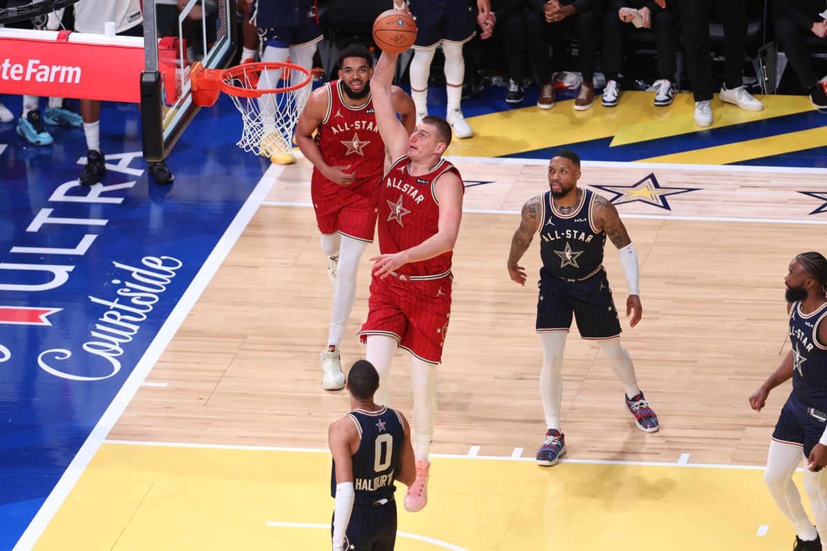 Feb 18, 2024; Indianapolis, Indiana, USA; Western Conference center Nikola Jokic (15) of the Denver Nuggets dunks the ball against Eastern Conference guard Tyrese Halliburton (0) of the Indiana Pacers and guard Damian Lillard (0) of the Milwaukee Bucks during the fourth quarter in the 73rd NBA All Star game at Gainbridge Fieldhouse. Mandatory Credit: Trevor Ruszkowski-Imagn Images