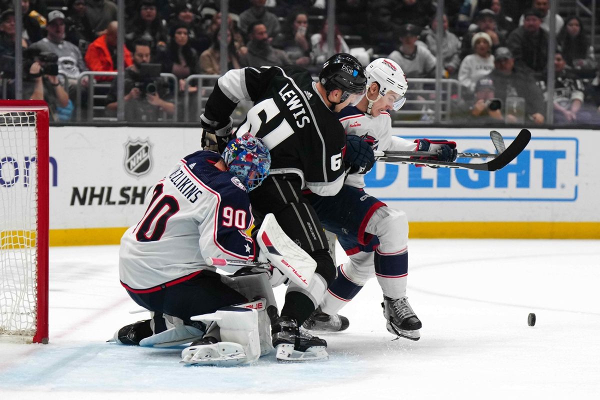 Feb 20, 2024; Los Angeles, California, USA; LA Kings center Trevor Lewis (61) battles for the puck with Columbus Blue Jackets goaltender Elvis Merzlikins (90) and defenseman Jake Bean (22) in the second period at Crypto.com Arena. Mandatory Credit: Kirby Lee-Imagn Images