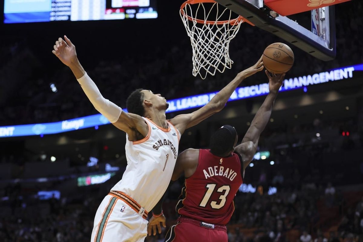 Feb 7, 2024; Miami, Florida, USA; San Antonio Spurs center Victor Wembanyama (1) blocks a shot against Miami Heat center Bam Adebayo (13) during the first quarter at Kaseya Center.