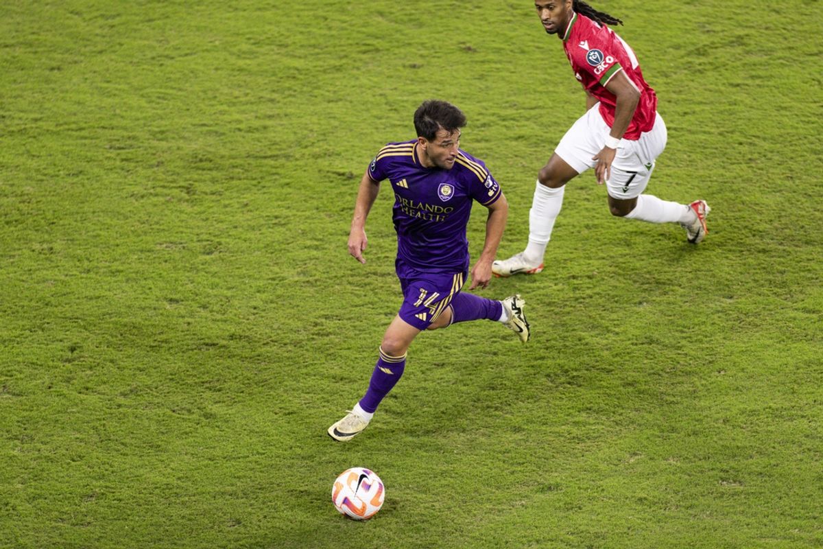 Feb 27, 2024; Orlando, FL, USA; Orlando City midfielder Nico Lodeiro (14) dribbles past Calvary FC forward Ali Musse (7) in the second half at Inter&Co Stadium. Mandatory Credit: Morgan Tencza-Imagn Images