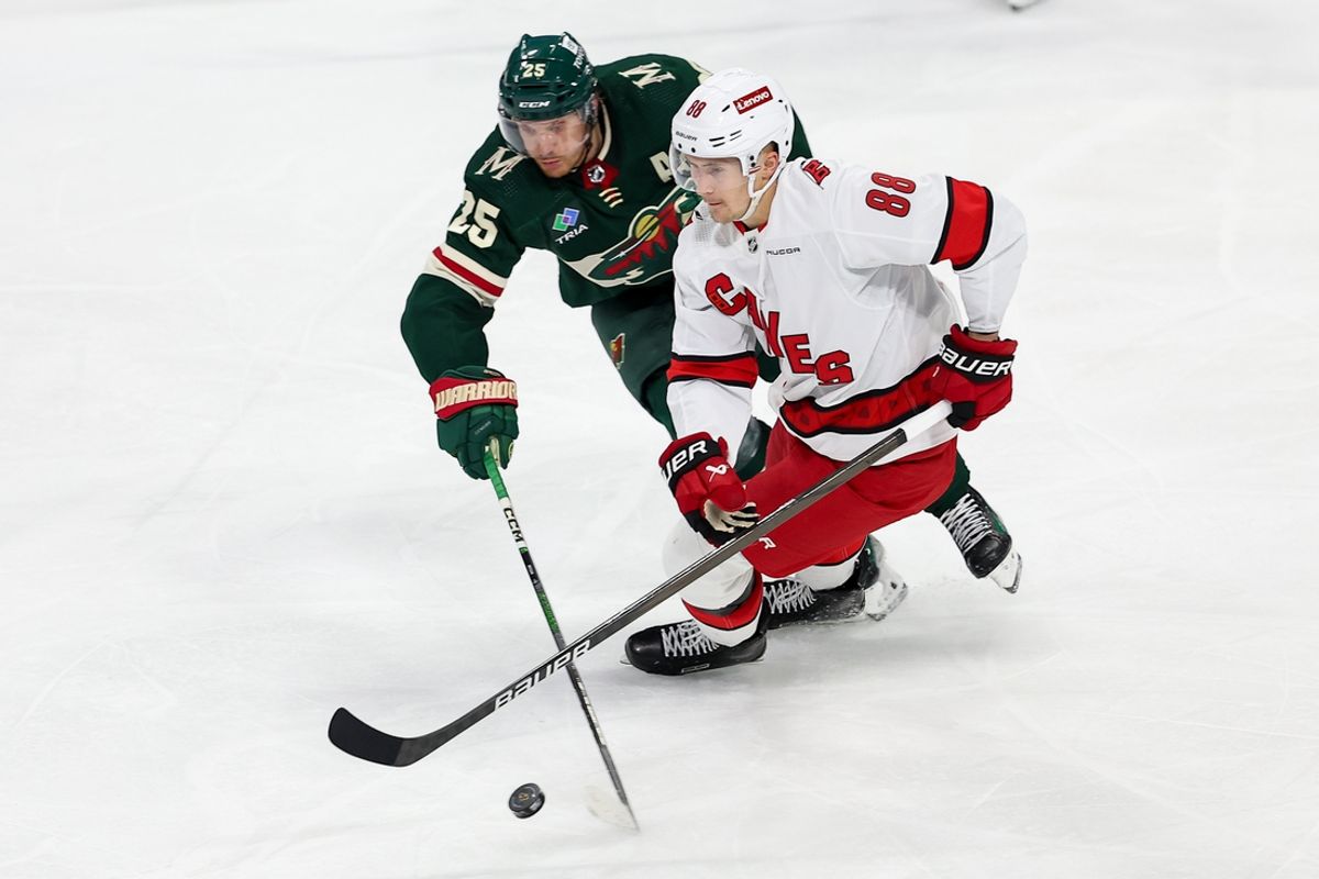 Feb 27, 2024; Saint Paul, Minnesota, USA; Carolina Hurricanes center Martin Necas (88) and Minnesota Wild defenseman Jonas Brodin (25) compete for the puck during the third period at Xcel Energy Center. Mandatory Credit: Matt Krohn-Imagn Images