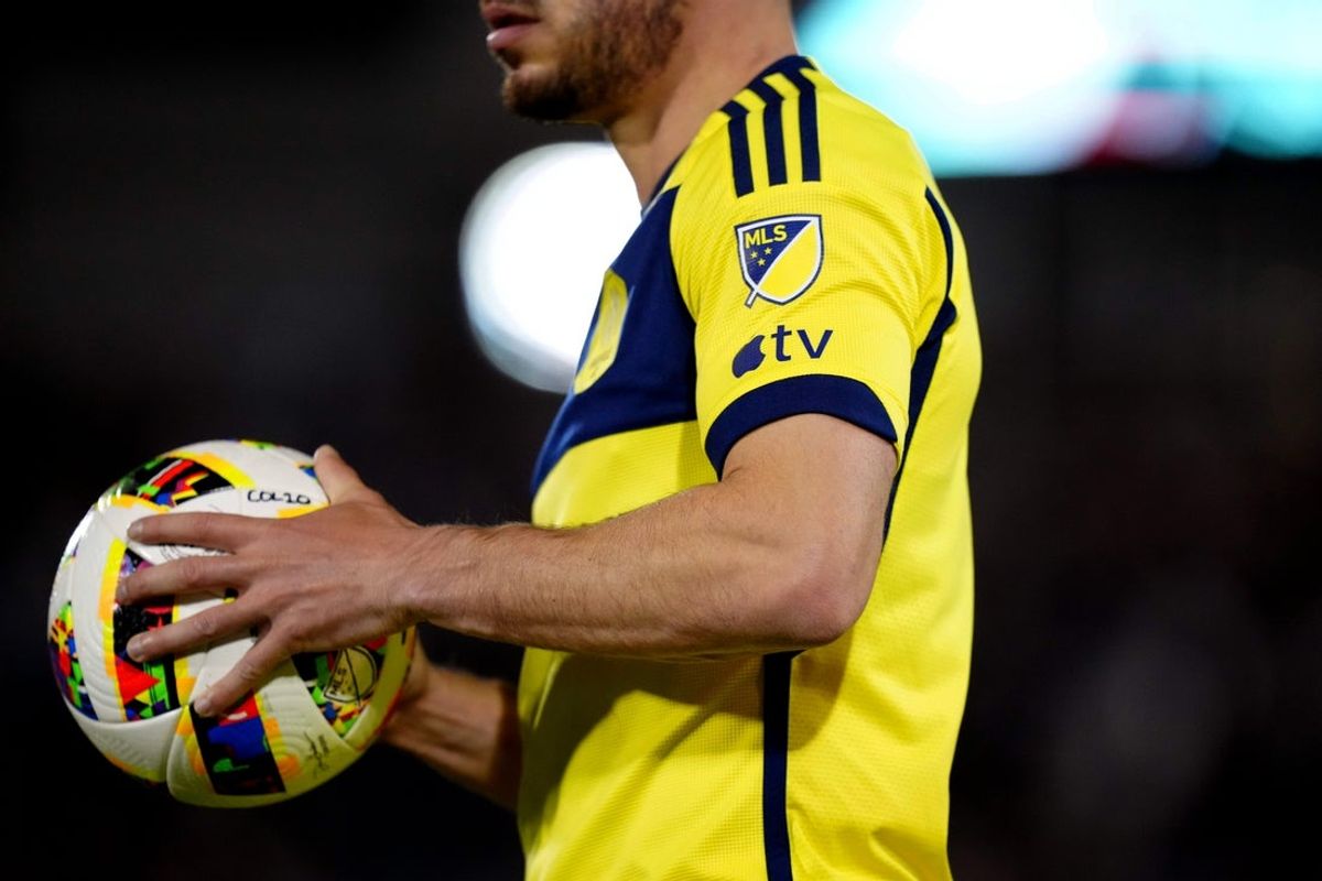 Mar 2, 2024; Commerce City, Colorado, USA; The MLS and Apple TV logo patches are seen on the sleeve of a Nashville SC player during the second half against the Colorado Rapids at Dick's Sporting Goods Park. Mandatory Credit: Ron Chenoy-Imagn Images