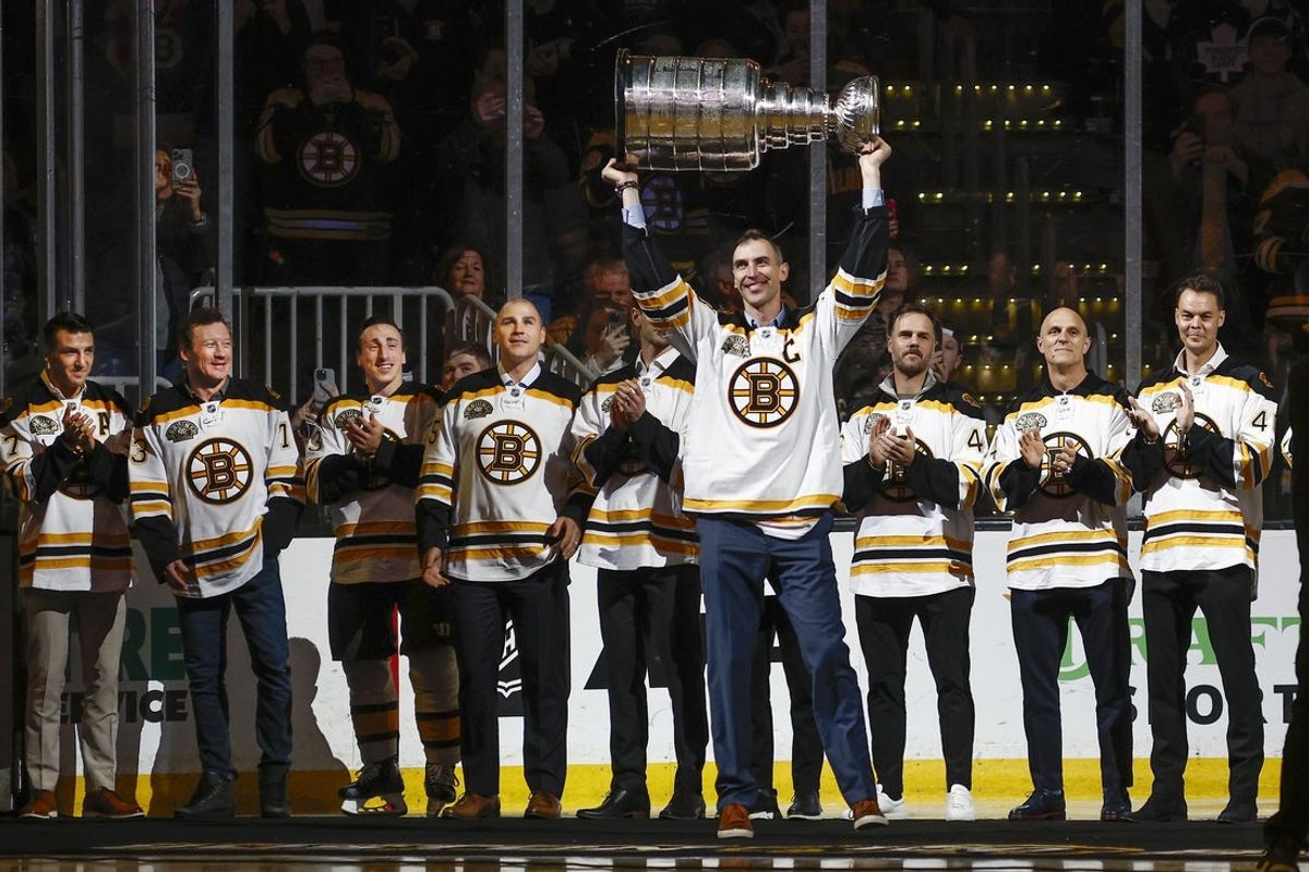 Mar 7, 2024; Boston, Massachusetts, USA; In ceremonies honoring the 100th season of the Boston Bruins, former captain Zdeno Chara raises the Stanley Cup as teammates from their 2011 championship team look on before the game between the Boston Bruins and the Toronto Maple Leafs at TD Garden. Mandatory Credit: Winslow Townson-Imagn Images