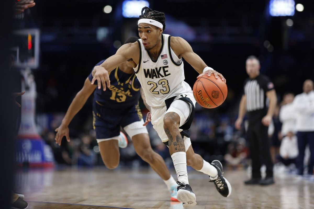 Mar 13, 2024; Washington, D.C., USA; Wake Forest Demon Deacons guard Hunter Sallis (23) drives to the basket past Notre Dame Fighting Irish forward Tae Davis (13) in the second half at Capital One Arena. Mandatory Credit: Geoff Burke-Imagn Images