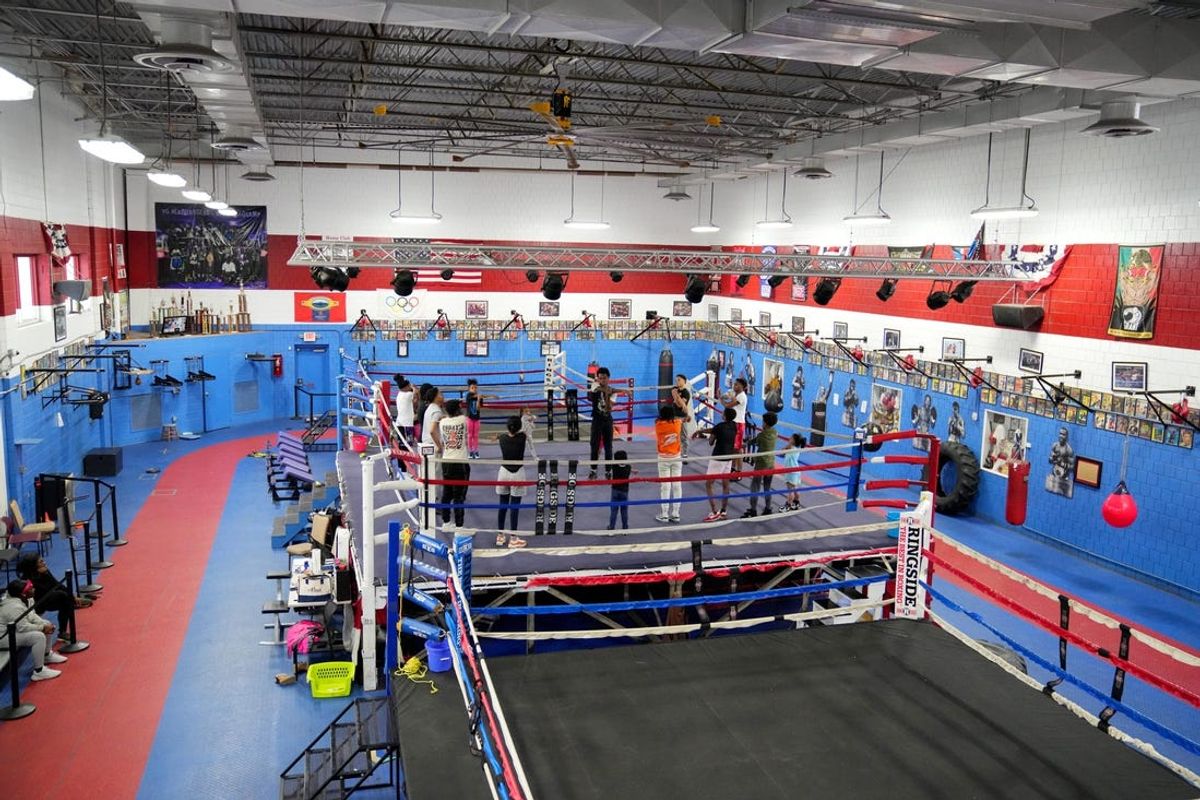 Youth boxers stretch at center ring before training, Monday, March 18, 2024, at Golden Gloves boxing gym in the Over-the-Rhine Recreation Center in Cincinnati. The Cincinnati Golden Gloves for Youth is aiming to move from its Over-the-Rhine home at 1715 Republic St. to the former Elmwood Place Elementary School at 400 Maple St.
