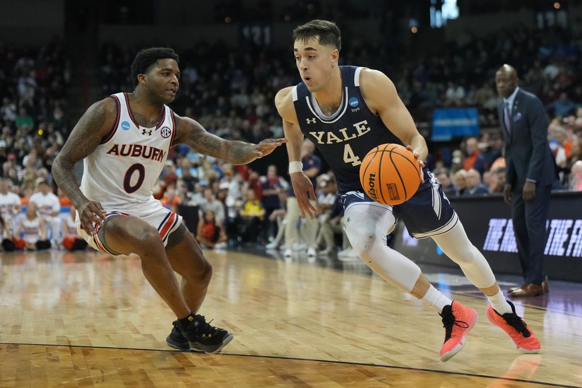 Mar 22, 2024; Spokane, WA, USA; Yale Bulldogs guard John Poulakidas (4) drives to the basket against Auburn Tigers guard K.D. Johnson (0)  during the second half of a game in the first round of the 2024 NCAA Tournament at Spokane Veterans Memorial Arena. Mandatory Credit: Kirby Lee-Imagn Images