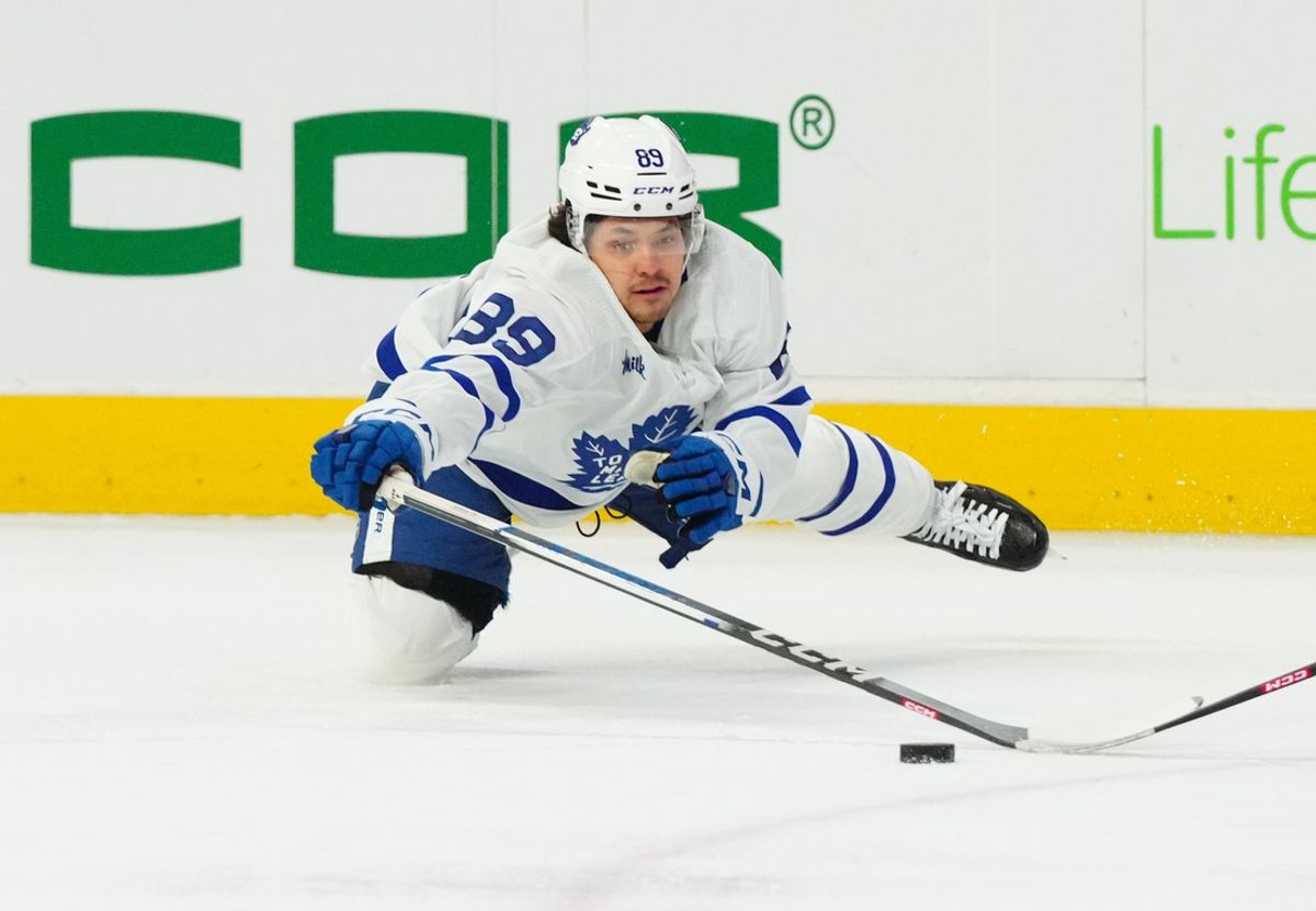 Mar 24, 2024; Raleigh, North Carolina, USA;  Toronto Maple Leafs left wing Nicholas Robertson (89) dives to poke the puck away from a Carolina Hurricanes player during the first period at PNC Arena. Mandatory Credit: James Guillory-Imagn Images