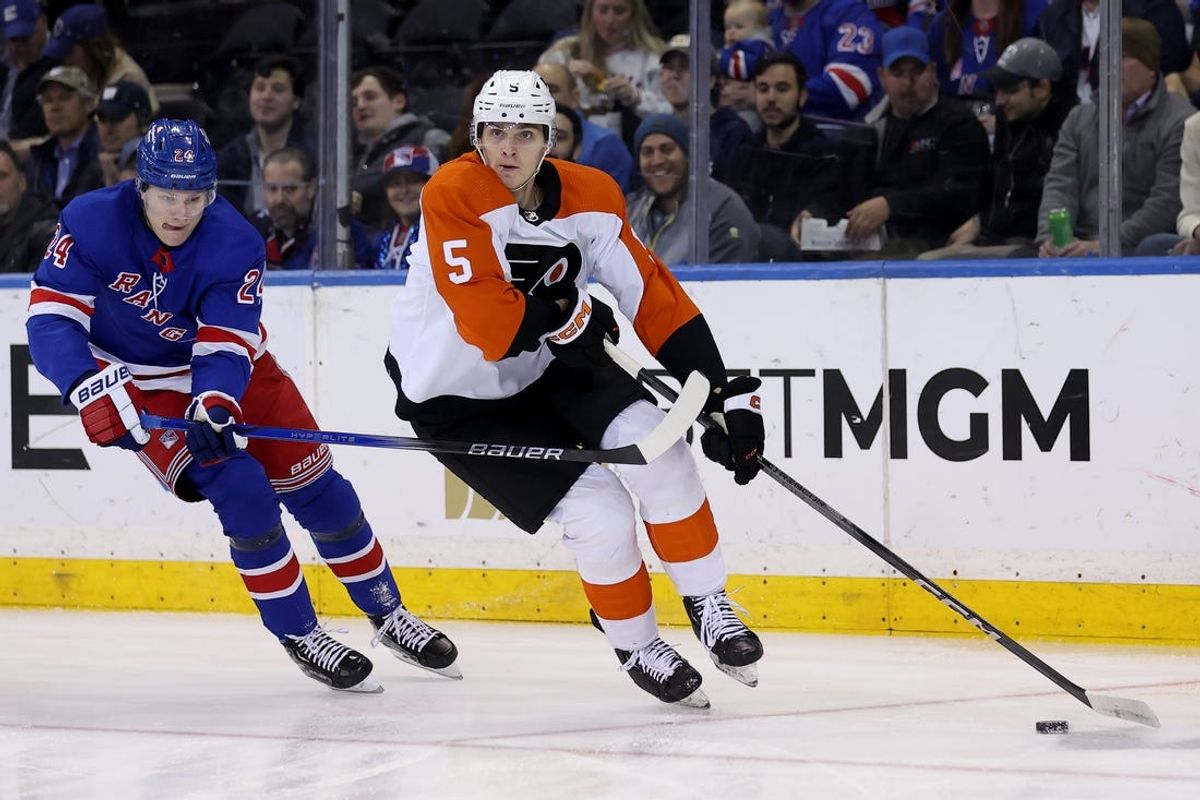 Mar 26, 2024; New York, New York, USA; Philadelphia Flyers defenseman Egor Zamula (5) controls the puck against New York Rangers right wing Kaapo Kakko (24) during the first period at Madison Square Garden. Mandatory Credit: Brad Penner-USA TODAY Sports