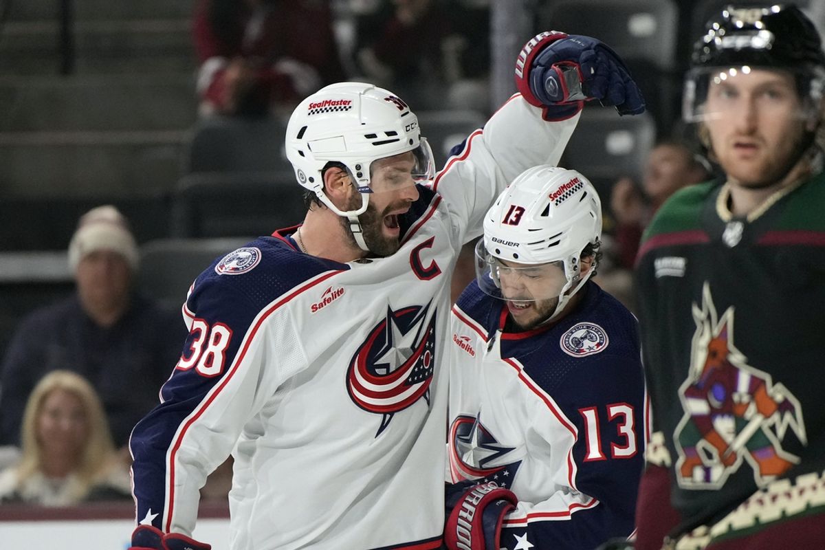 Mar 26, 2024; Tempe, Arizona, USA; Columbus Blue Jackets center Boone Jenner (38) celebrates with left wing Johnny Gaudreau (13) after scoring a goal against the Arizona Coyotes in the first period at Mullett Arena. Mandatory Credit: Rick Scuteri-Imagn Images