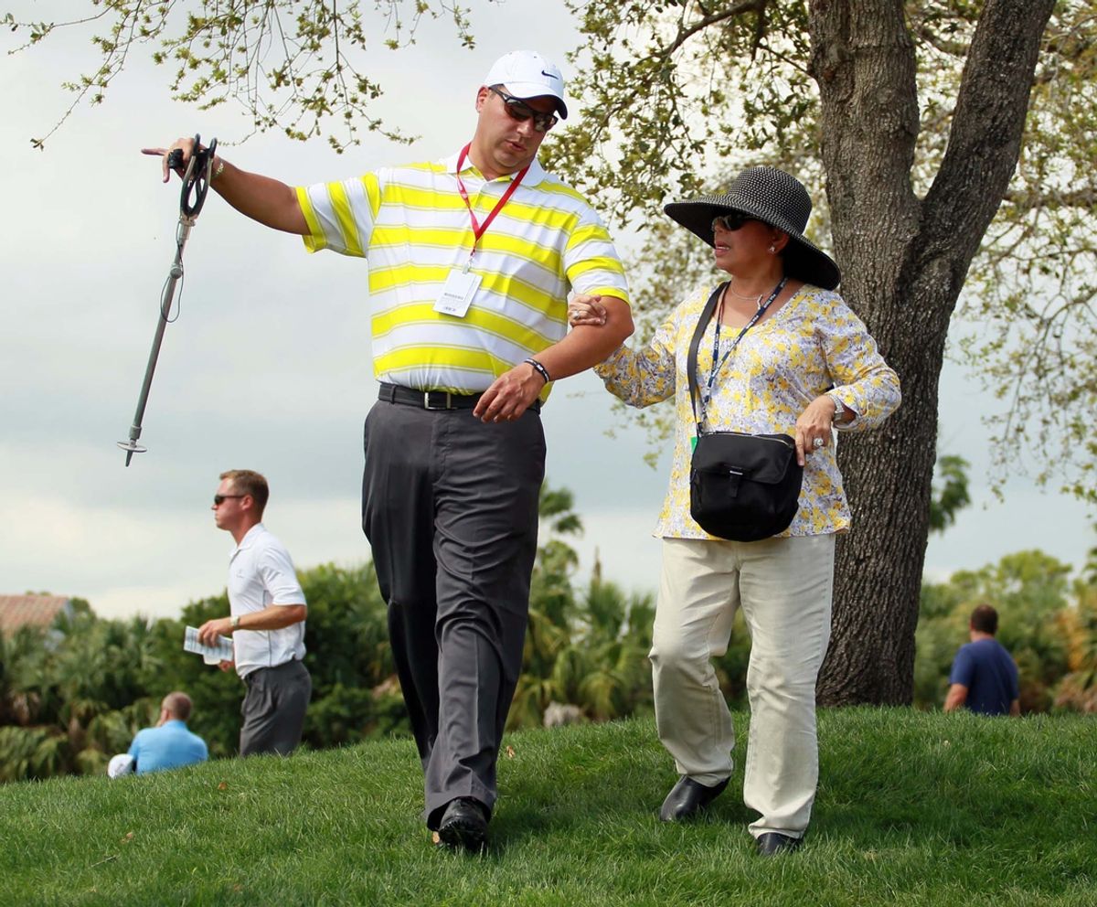 Tiger Wood's mother Kultida Woods, center, watches him play during the first round of the Honda Classic golf tournament in Palm Beach Gardens, Fla., Thursday, March 1, 2012.