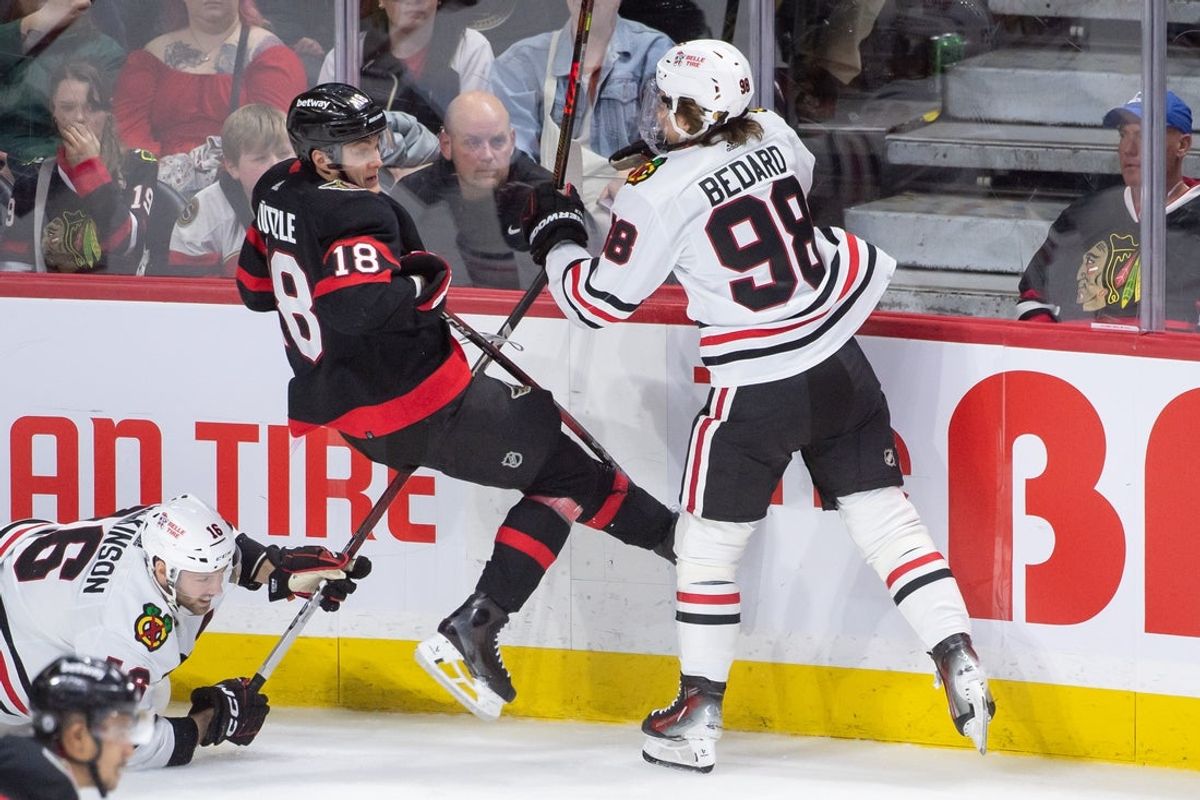 Mar 28, 2024; Ottawa, Ontario, CAN; Ottawa Senators center Tim Stutzle (18) is checked by Chicago Blackhawks center Connor Bedard (98) in the third period at the Canadian Tire Centre. Mandatory Credit: Marc DesRosiers-Imagn Images