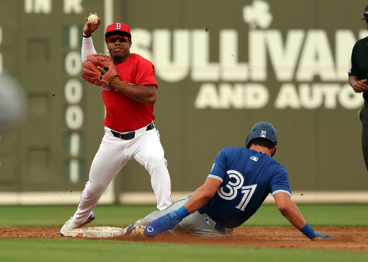 Mar 3, 2024; Fort Myers, Florida, USA; Boston Red Sox second baseman Enmanuel Valdez (47) forces out Toronto Blue Jays outfielder Cam Eden (31) and throws the ball to first base for a double play during the third inning at JetBlue Park at Fenway South.