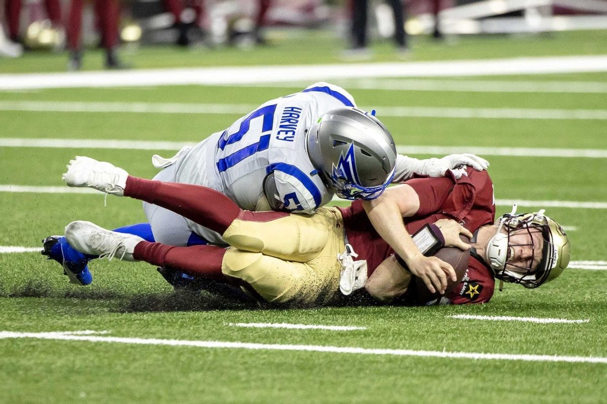 Mar 30, 2024; Detroit, MI, USA; Michigan Panthers quarterback E.J. Perry (4) dives for a first down as he is tackled by St. Louis Battlehawks linebacker Willie Harvey during the second half at Ford Field. Mandatory Credit: David Reginek-USA TODAY Sports