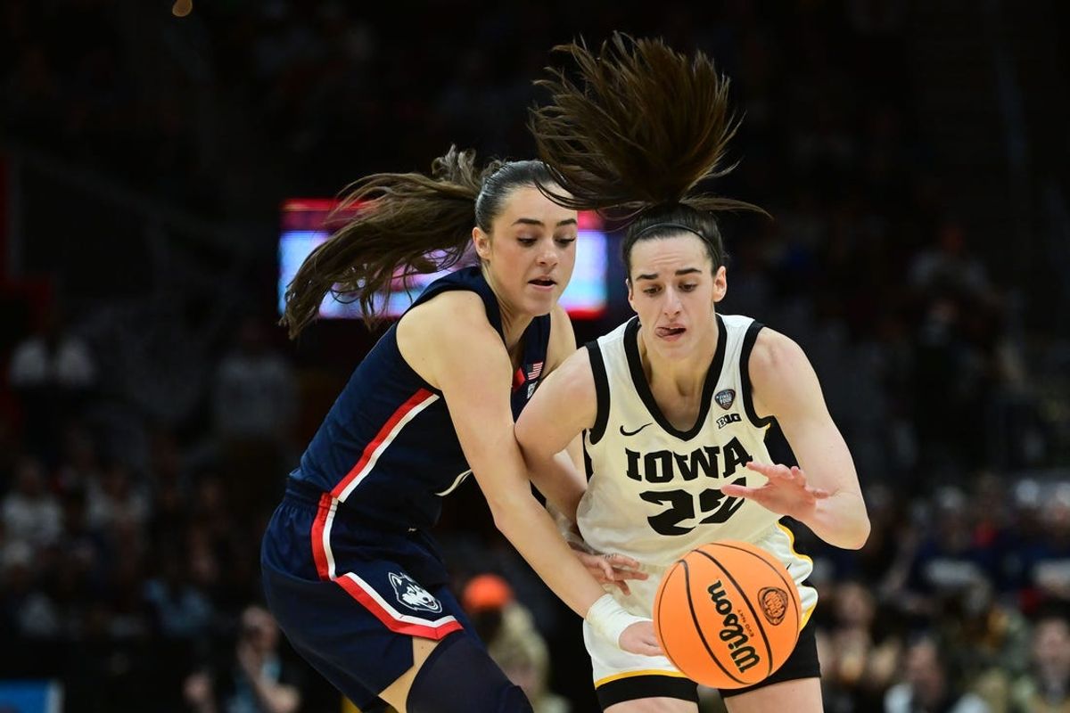 Apr 5, 2024; Cleveland, OH, USA; Iowa Hawkeyes guard Caitlin Clark (22) dribbles the ball past Connecticut Huskies guard Nika Muhl (10) in the semifinals of the Final Four of the womens 2024 NCAA Tournament at Rocket Mortgage FieldHouse. Mandatory Credit: Ken Blaze-USA TODAY Sports