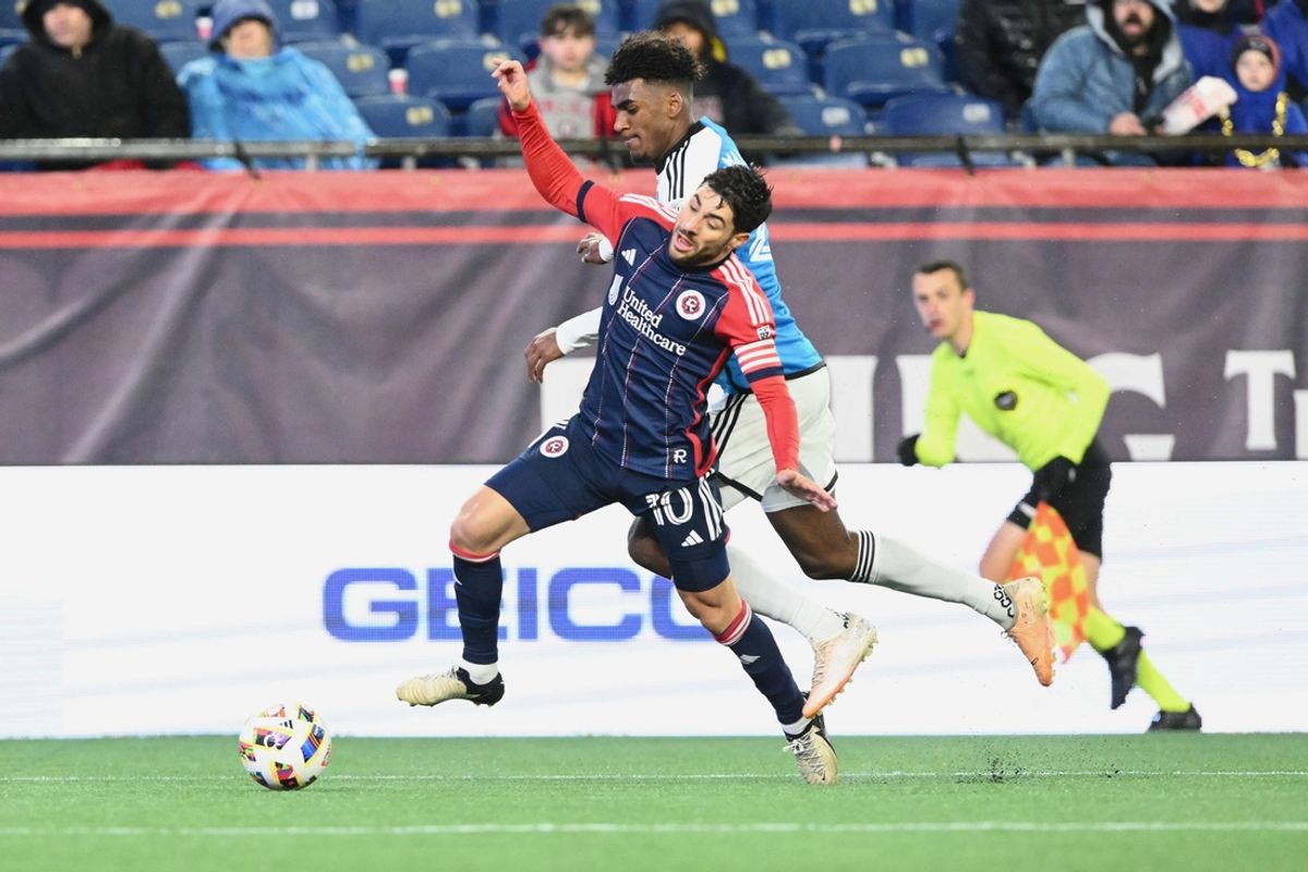 Apr 6, 2024; Foxborough, Massachusetts, USA; New England Revolution midfielder Carles Gil (10) battles with Charlotte FC defender Adilson Malanda (29) for the ball during their MLS soccer match at Gillette Stadium. Mandatory Credit: Brian Fluharty-Imagn Images
