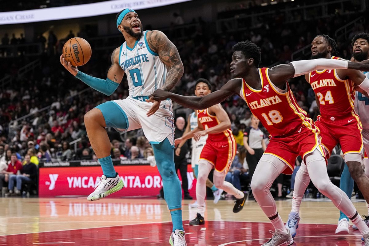 Apr 10, 2024; Atlanta, Georgia, USA; Charlotte Hornets forward Miles Bridges (0) tries to shoot over Atlanta Hawks forward Mouhamed Gueye (18) during the second half at State Farm Arena. Mandatory Credit: Dale Zanine-Imagn Images