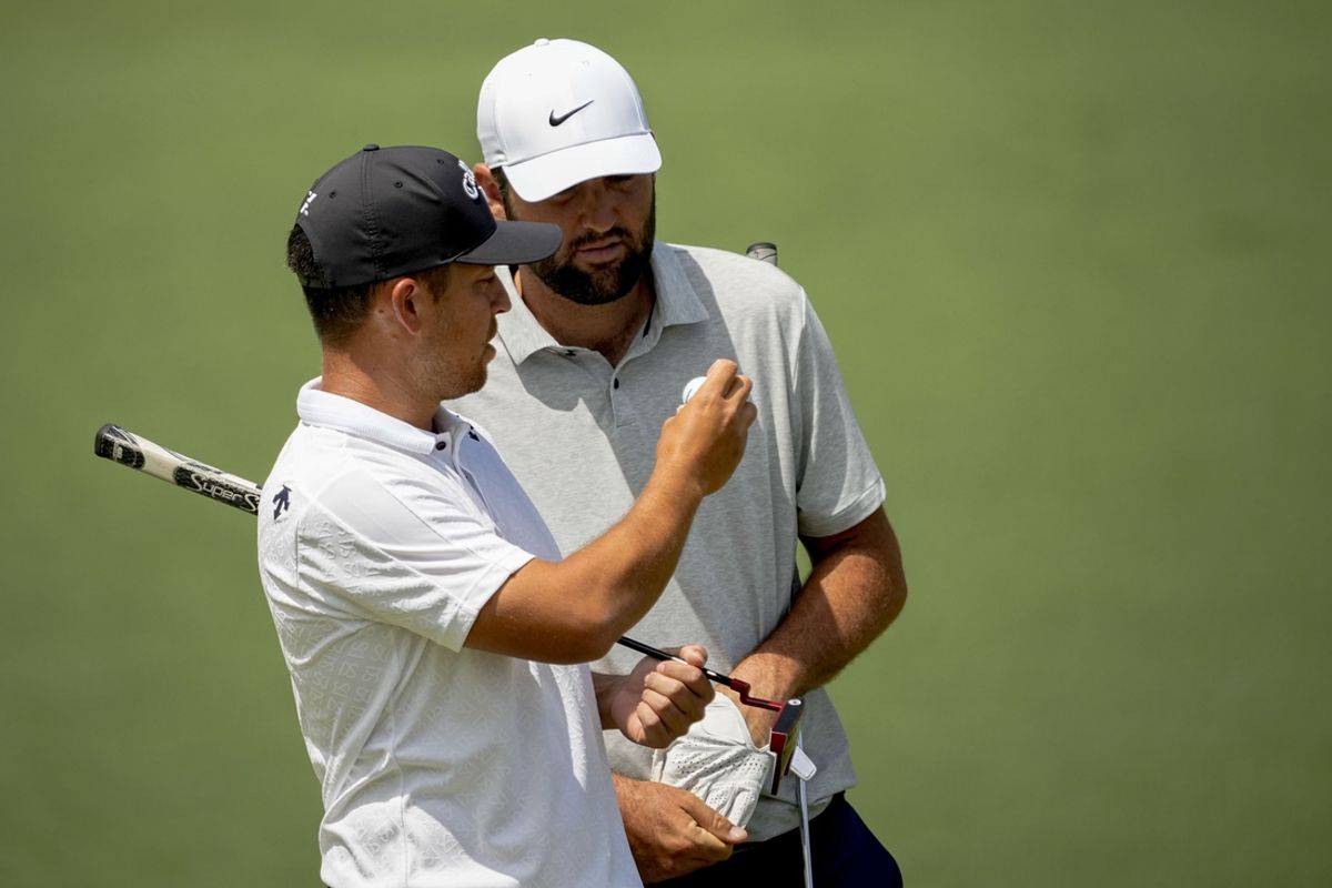 Apr 11, 2024; Augusta, Georgia, USA; Xander Schauffele shows Scottie Scheffler his ball on the no. 2 green before switching balls during the first round of the Masters Tournament. Mandatory Credit: Adam Cairns-USA TODAY Network
