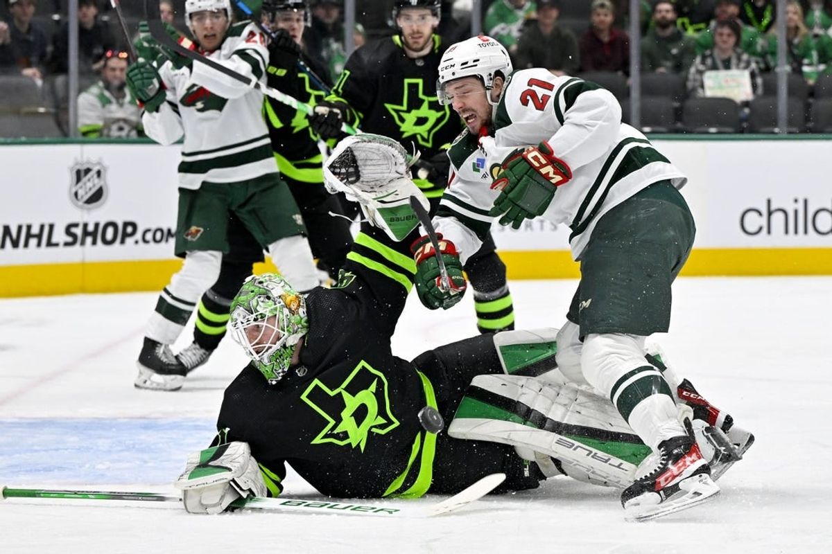 Jan 10, 2024; Dallas, Texas, USA; Minnesota Wild right wing Brandon Duhaime (21) is hit by a Wild slap shot as he attempts a shot on Dallas Stars goaltender Scott Wedgewood (41) during the first period at the American Airlines Center.