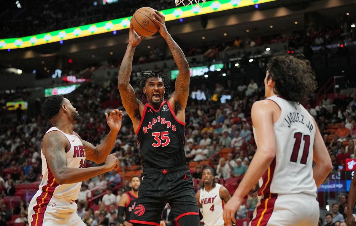 Apr 14, 2024; Miami, Florida, USA;  Toronto Raptors center Christian Koloko (35) grabs a rebound over Miami Heat forward Haywood Highsmith (24) during the second half at Kaseya Center. Mandatory Credit: Jim Rassol-Imagn Images
