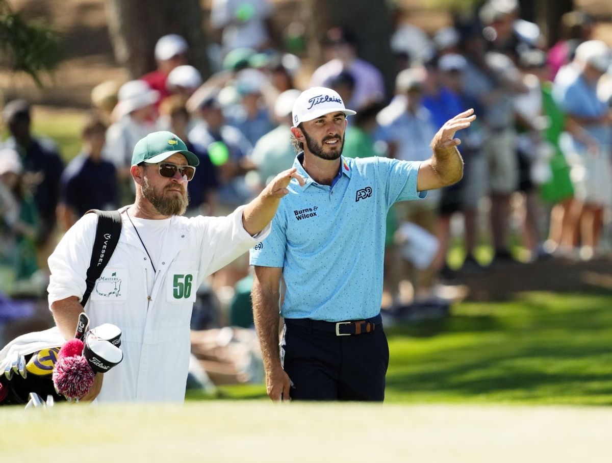 Apr 14, 2024; Augusta, Georgia, USA; Max Homa consults with caddie Joe Greiner before chipping on No. 7 during the final round of the Masters Tournament. Mandatory Credit: Rob Schumacher-USA TODAY Network