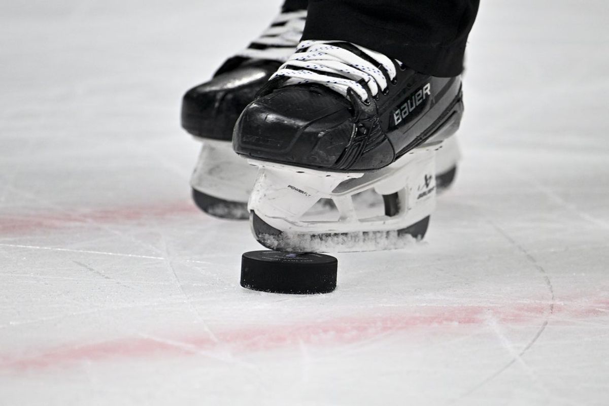 Apr 22, 2024; Dallas, Texas, USA; A view of an NHL hockey puck and the skates of an MHL referee during the third period between the Dallas Stars and the Vegas Golden Knights in game one of the first round of the 2024 Stanley Cup Playoffs at the American Airlines Center. Mandatory Credit: Jerome Miron-Imagn Images