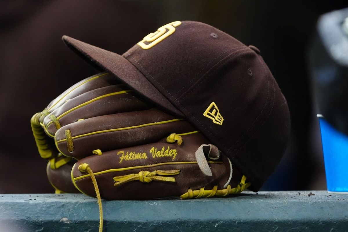 Apr 25, 2024; Denver, Colorado, USA; Detailed view of a San Diego Padres cap and glove. Mandatory Credit: Ron Chenoy-Imagn Images