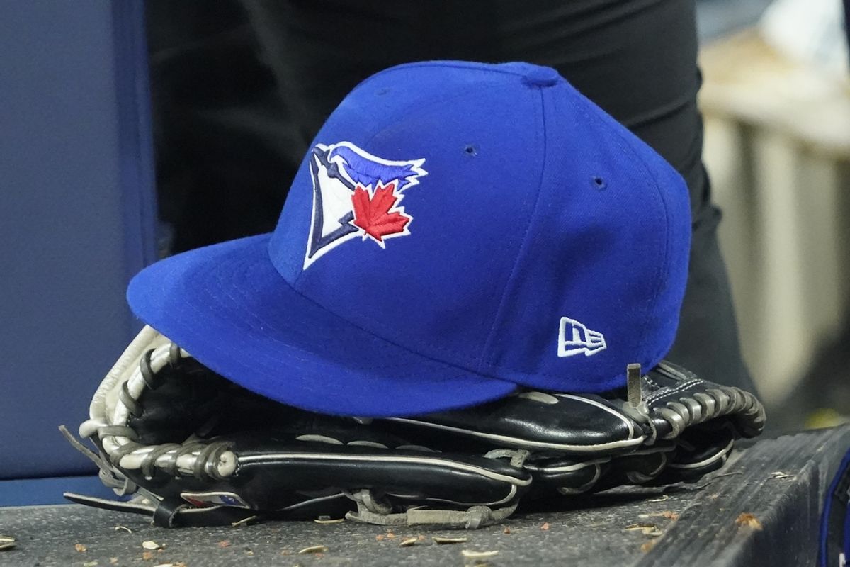 Apr 27, 2024; Toronto, Ontario, CAN; A Toronto Blue Jays hat and glove in the dugout during the third inning against the Los Angeles Dodgers at Rogers Centre. Mandatory Credit: John E. Sokolowski-Imagn Images